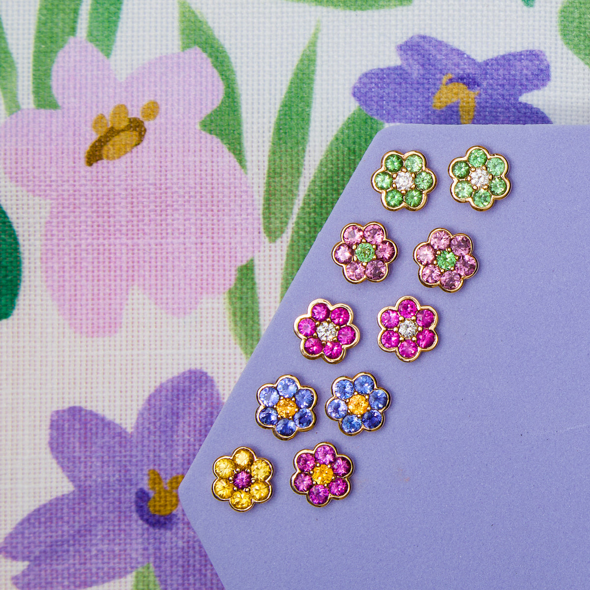 Five pairs of Blooms Stud Earrings on lilac - Merelani mint garnet and diamond, rhodolite garnet and Merelani mint garnet, pink ruby and diamond, tanzanite and spessartite garnet, yellow sapphire and grape garnet