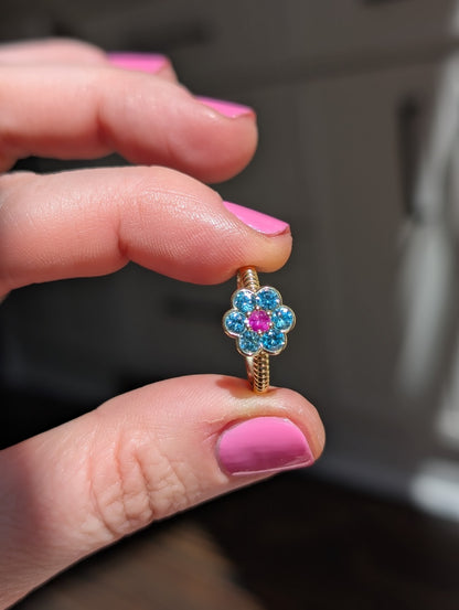 Blooms Medium Ring in blue zircon and pink ruby, close-up held in hand