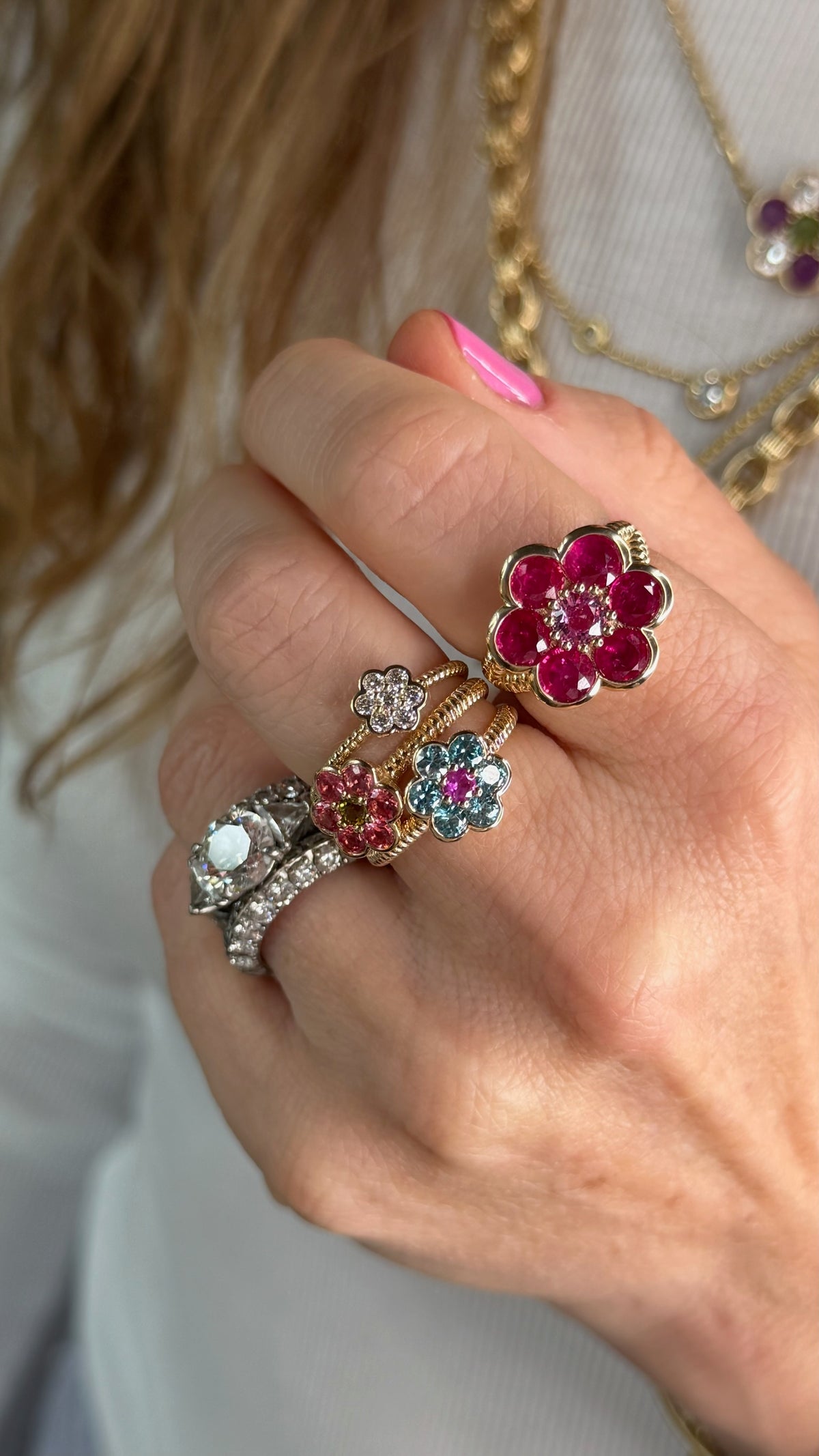 Blooms Large Ring in pink ruby and pink sapphire worn on the hand, stacked with Blooms Medium Rings and a diamond Mini Ring