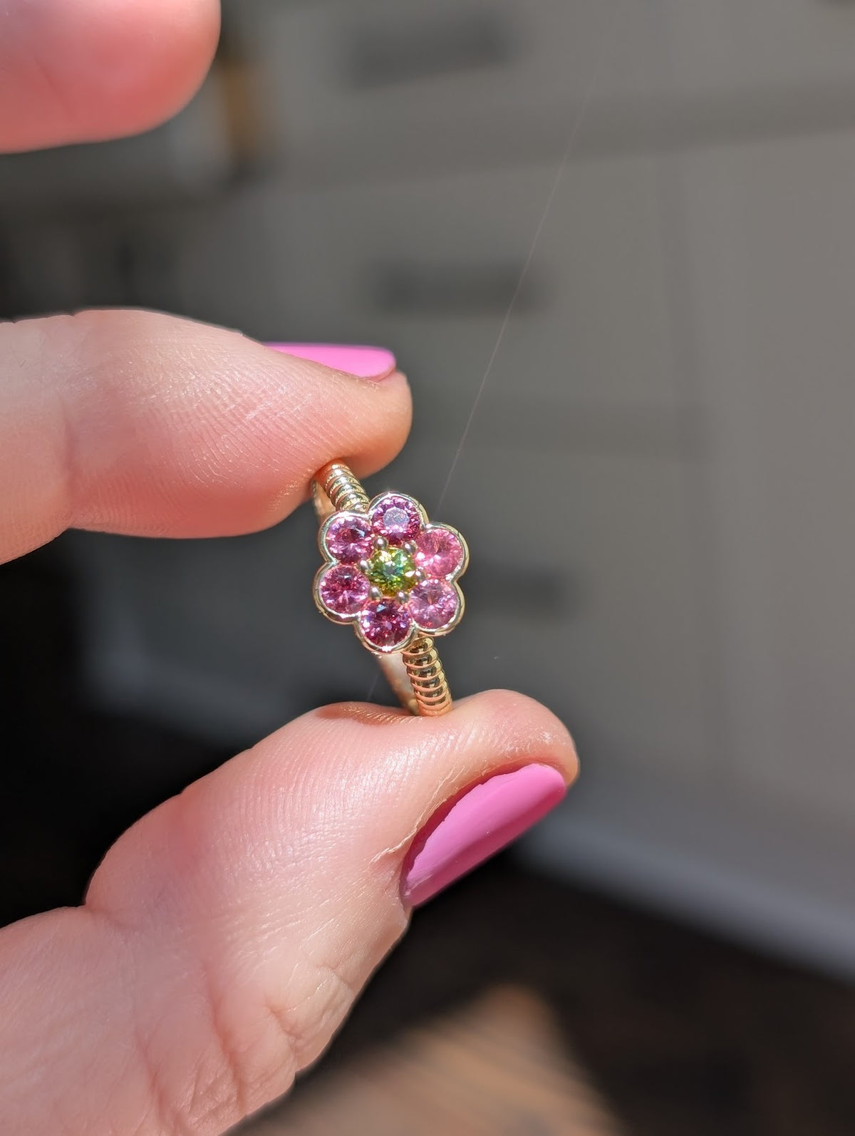 Blooms Medium Ring in Mehenge spinel and tourmaline, close-up held in hand