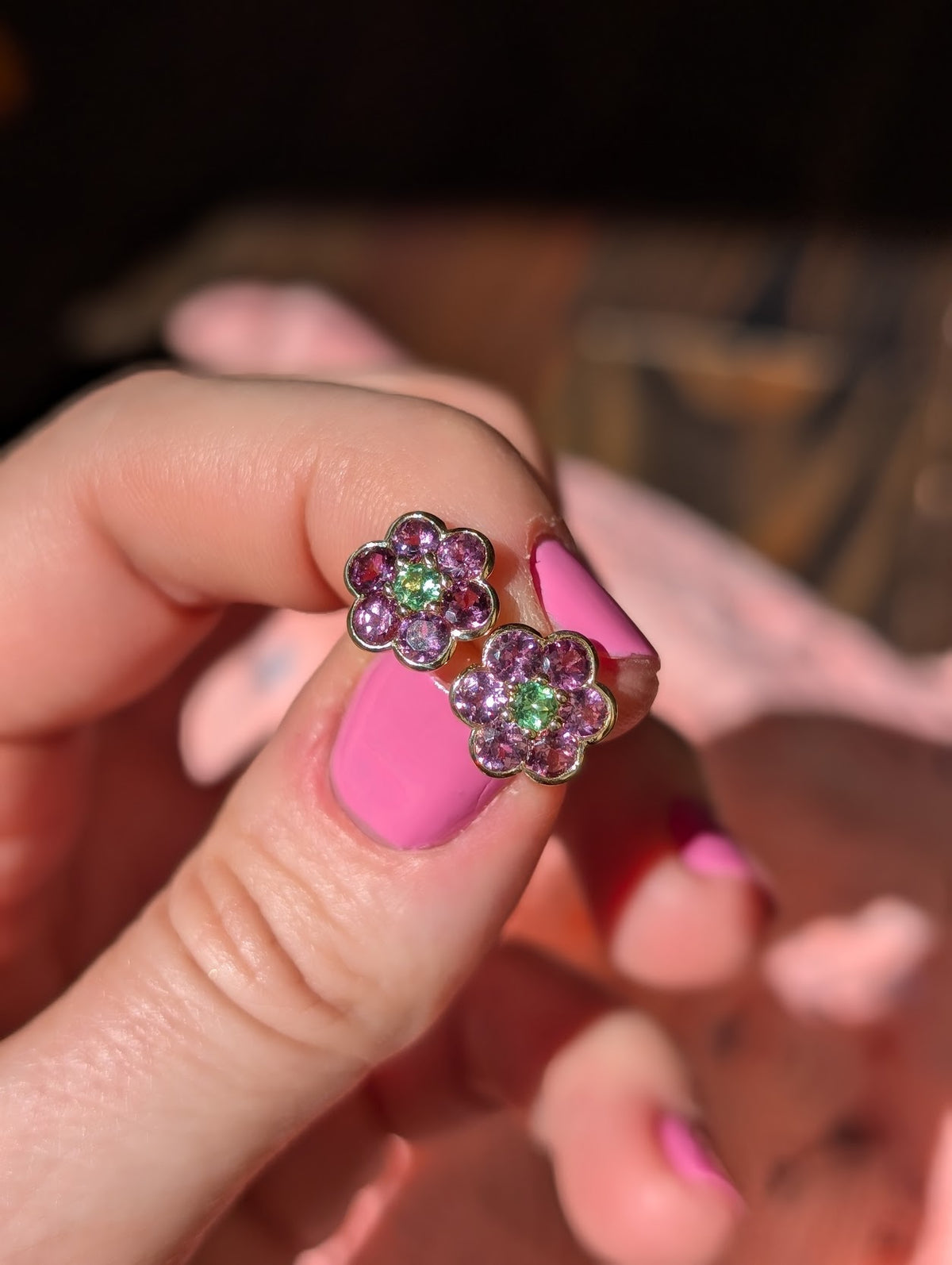 Blooms Stud Earrings in rhodolite garnet with Merelani mint garnet center, pair held in hand