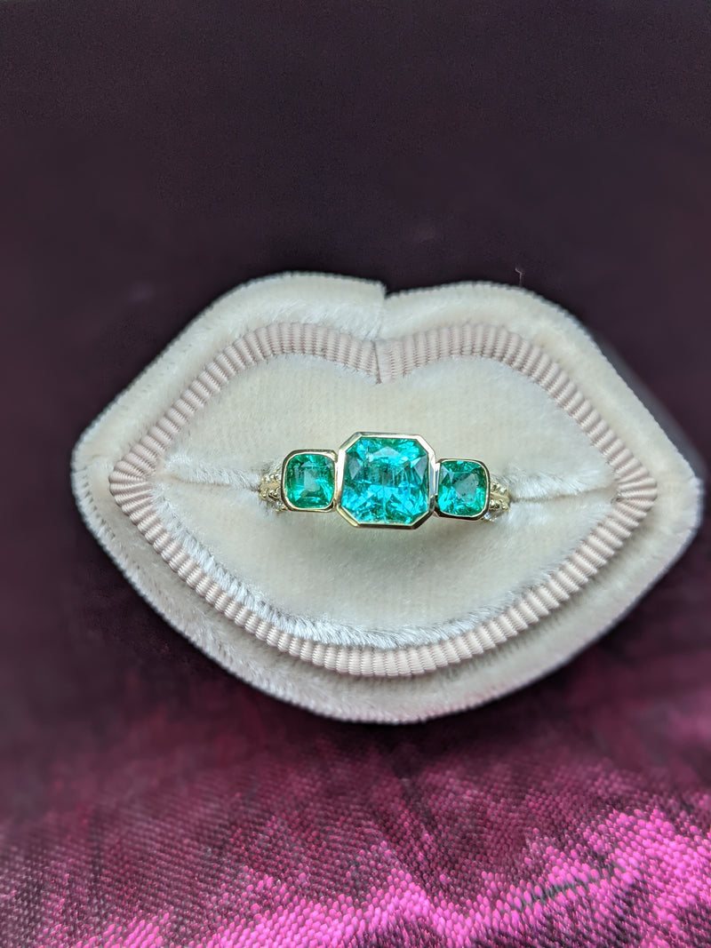 A stunning 3 stone ring with perfectly matched Columbian emeralds