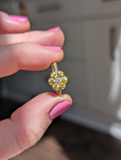 Blooms Medium Ring in yellow sapphire and diamond, close-up held in hand