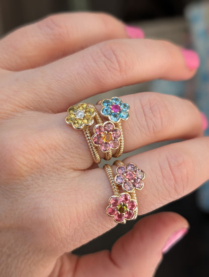 Five Blooms Medium Rings worn across two fingers, close-up