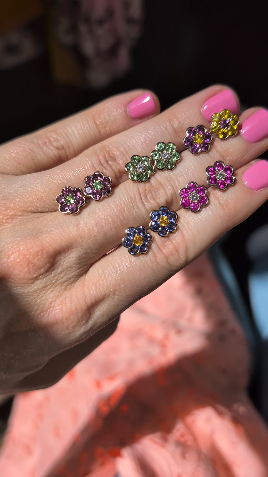 Video of five pairs of Blooms Stud Earrings held in hand in sunlight