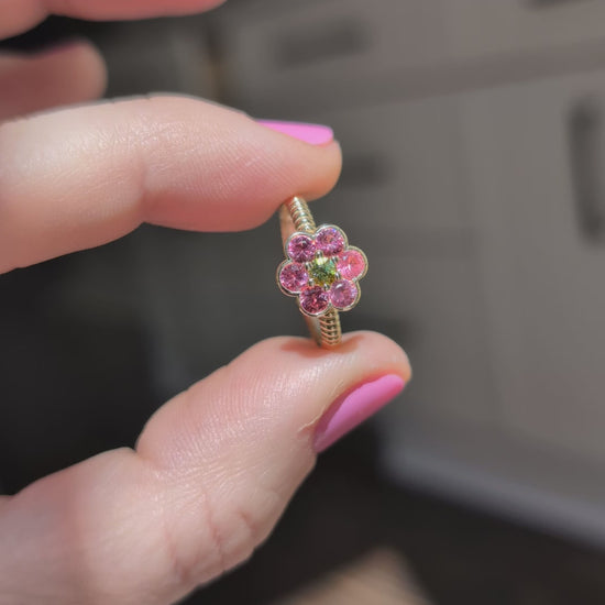 Video of the Blooms Medium Ring in Mehenge spinel and tourmaline held in sunlight