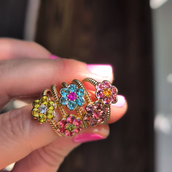 Video of five Blooms Medium Rings held in hand in sunlight, showing the sparkle of each stone