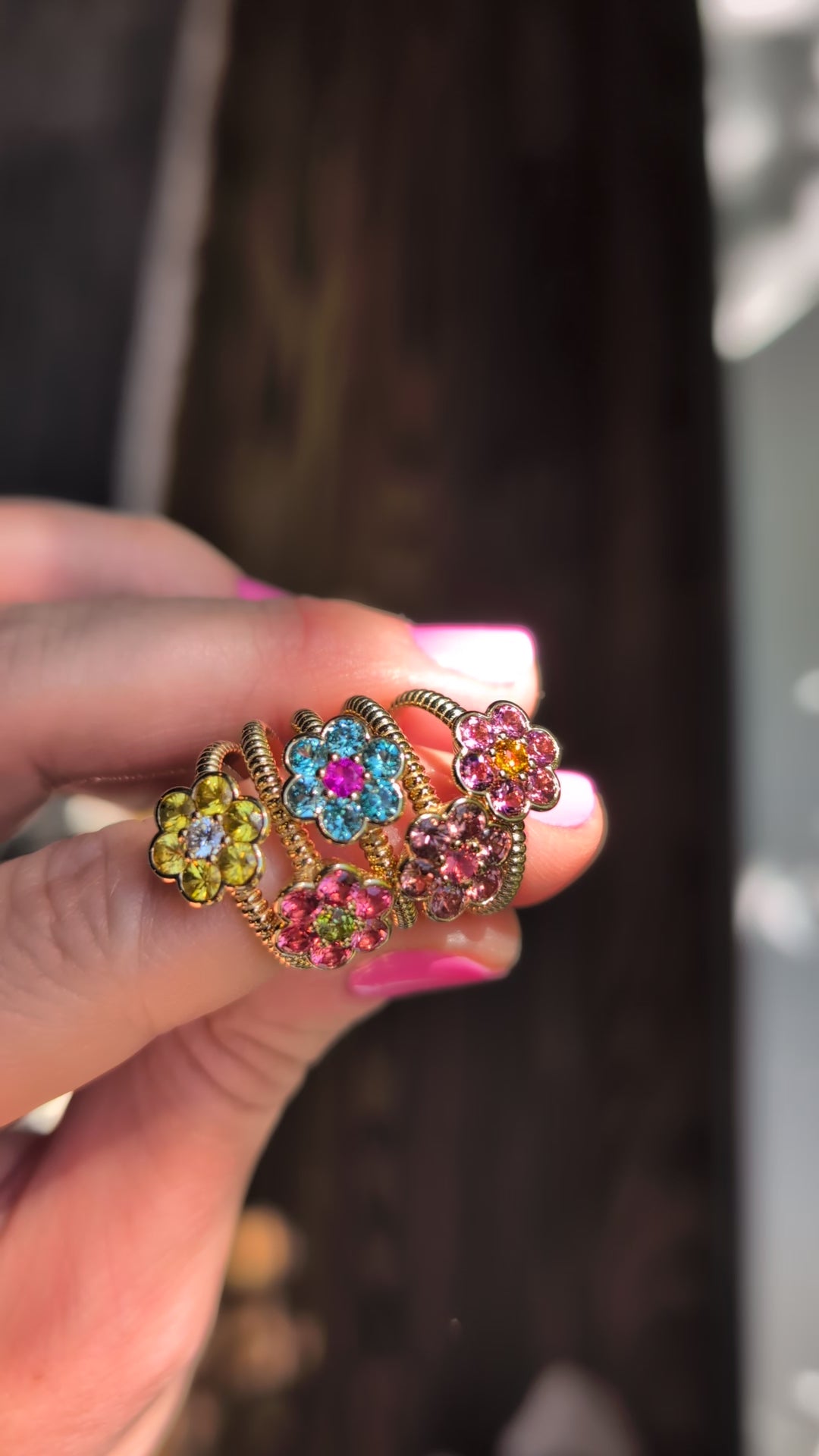 Video of five Blooms Medium Rings held in hand in sunlight, showing the sparkle of each stone