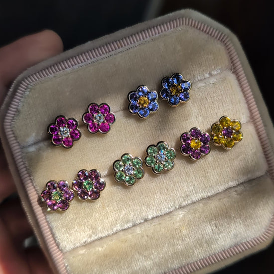 Video of five pairs of Blooms Stud Earrings in a velvet jewelry box in sunlight